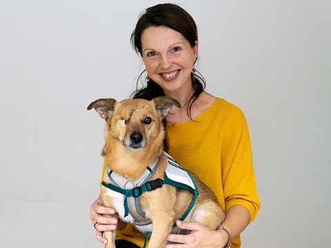 Foto der 4000. Mitarbeiterin mit ihrem Hund auf dem Schoß